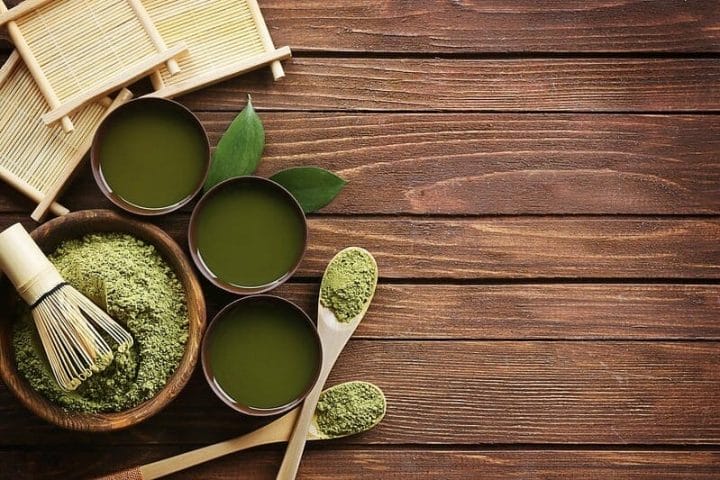 抹茶绿茶粉在沙拉碗和杯子里以液体形式存在。