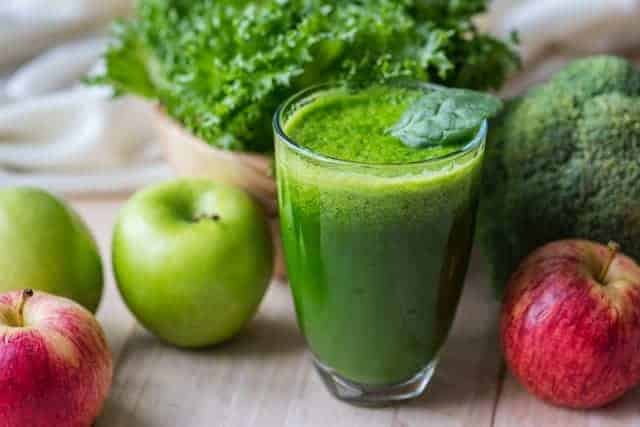 蔬菜绿色冰沙在玻璃杯和苹果
