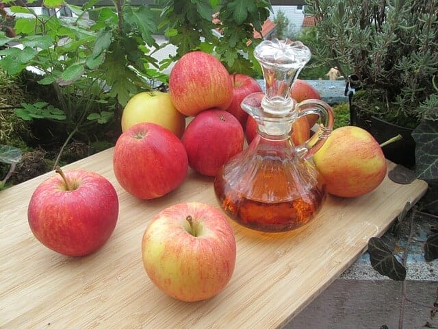 桌上的新鲜苹果和一瓶苹果醋
