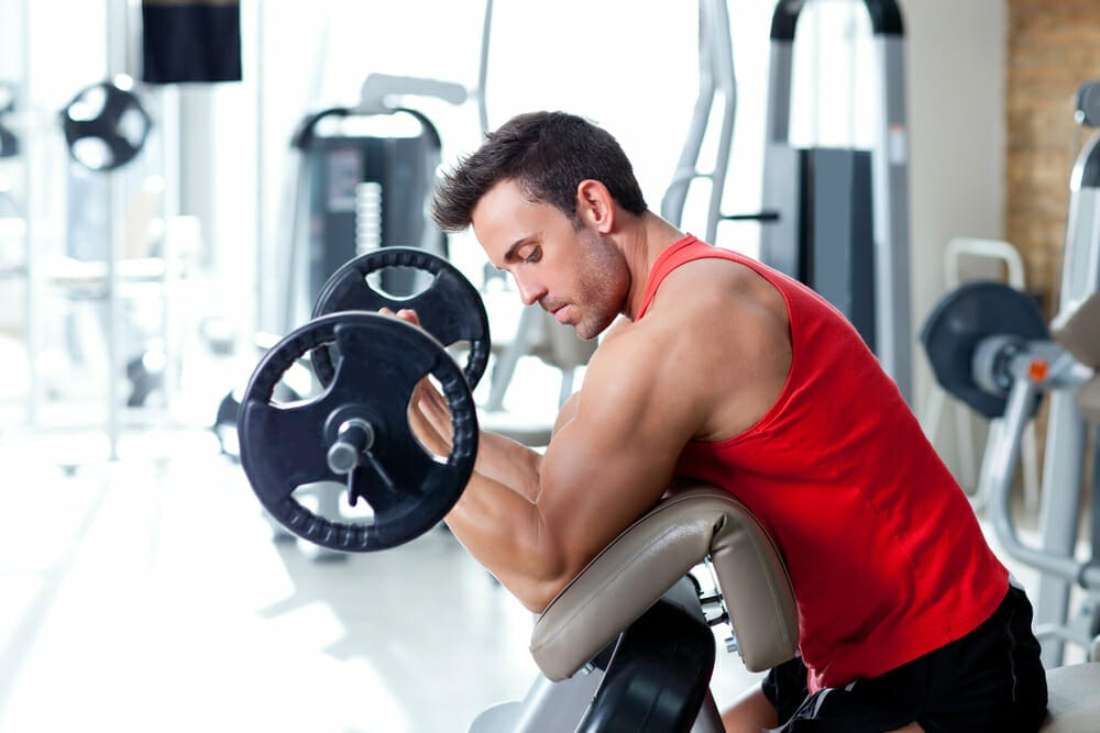 一名男子在健身房用杠铃锻炼。