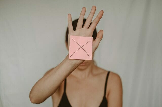 一个悲伤的女人拿着一个带X的纸盒在她面前晃来晃去