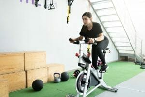 妇女在固定的自行车上进行训练